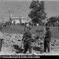 Plaza del Altozano. Obras en la calzada en la embocadura de las calles San Jacinto y San Jorge. Al fondo, el edificio El Faro, construido hacia 1922 como estación fluvial de vapores hacia Sanlúcar de Barrameda. 1958 ca. ©ICAS-SAHP, Fototeca Municipal de Sevilla, fondo Cubiles