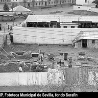 Plaza San Martín de Porres. Vista cenital de las obras de construcción del ambulatorio del Seguro de Enfermedad Amante Laffón junto al mercado del Tardón. En el terrizo, la atracción infantil conocida como Autódromo León. 1960-1962. ©ICAS-SAHP, Fototeca Municipal de Sevilla, fondo Serafín