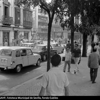 Tráfico rodado en la plaza del Duque de la Victoria. En la esquina con la plaza de la Campana, Casa Pinto, tienda de artículos fotográficos y electrodomésticos. 1971. ©ICAS-SAHP, Fototeca Municipal de Sevilla, fondo Cubiles